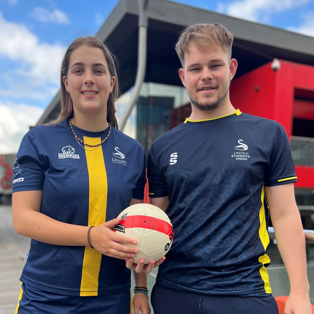 Two student footballers holding a football