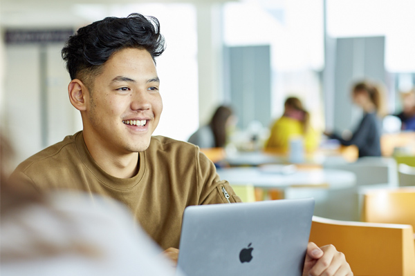 A student sat working at a laptop