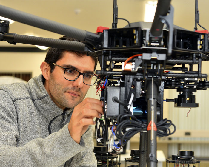 A student examines a piece of engineering equipment