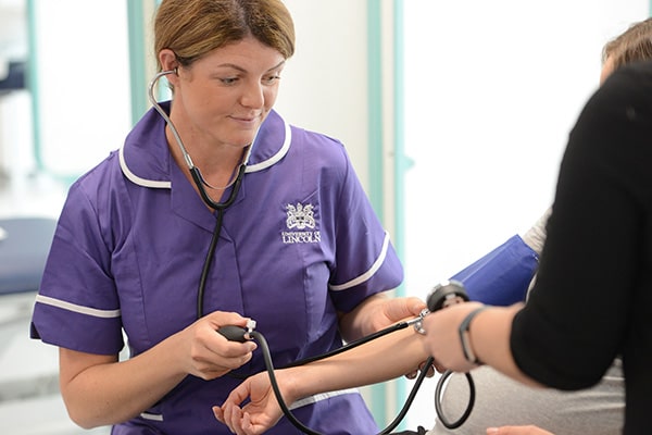 Nurse checking a patients blood pressure