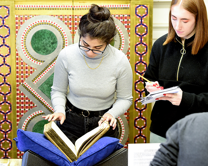 Students studying a manuscript