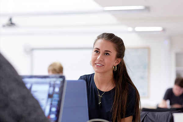 A woman with a laptop looking off camera