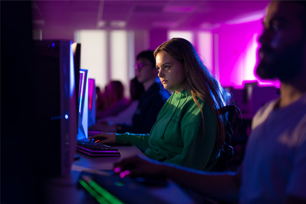 Female student in a green jumper looking at a computer