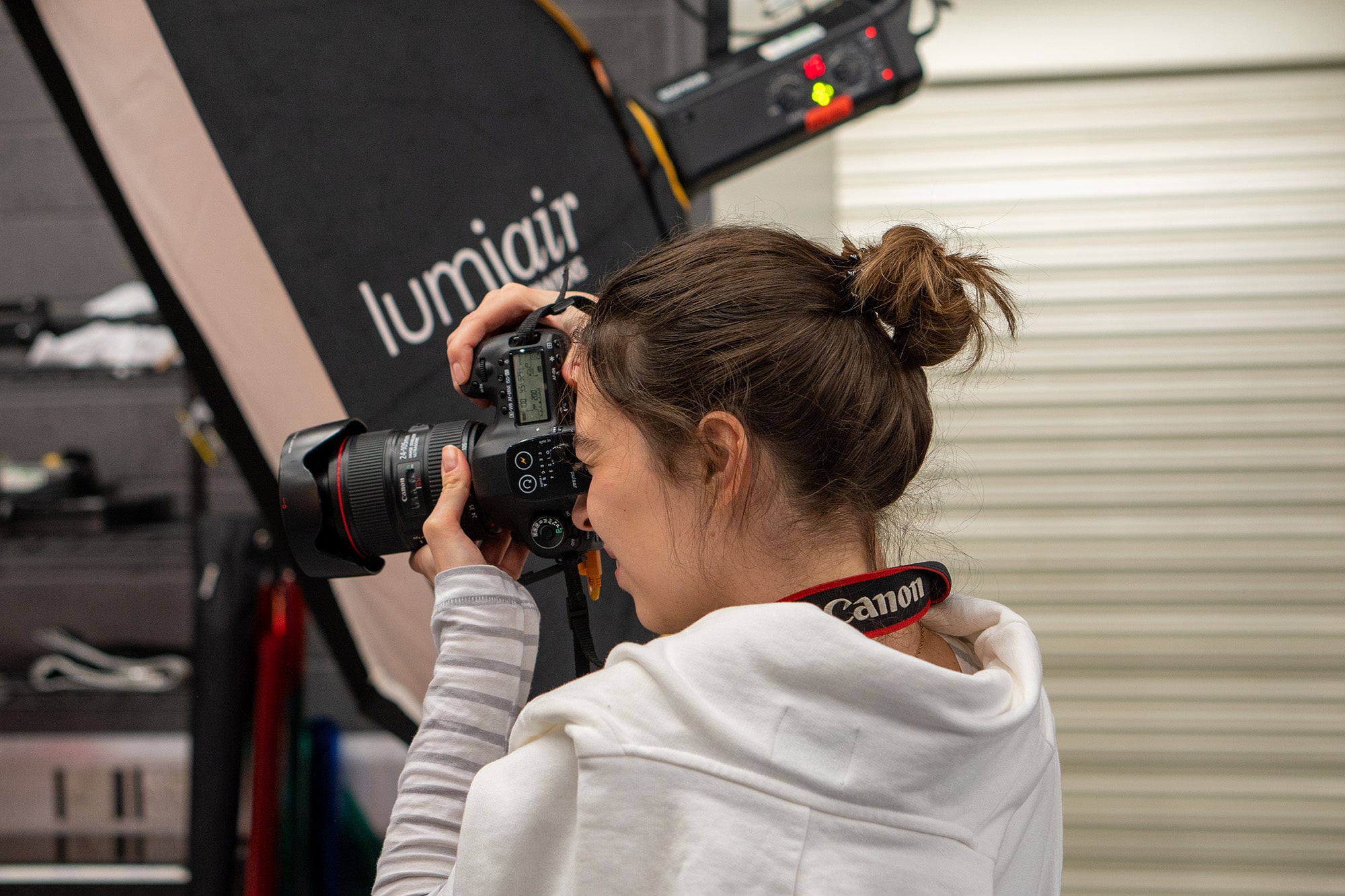 Female student in photo studio holding a camera