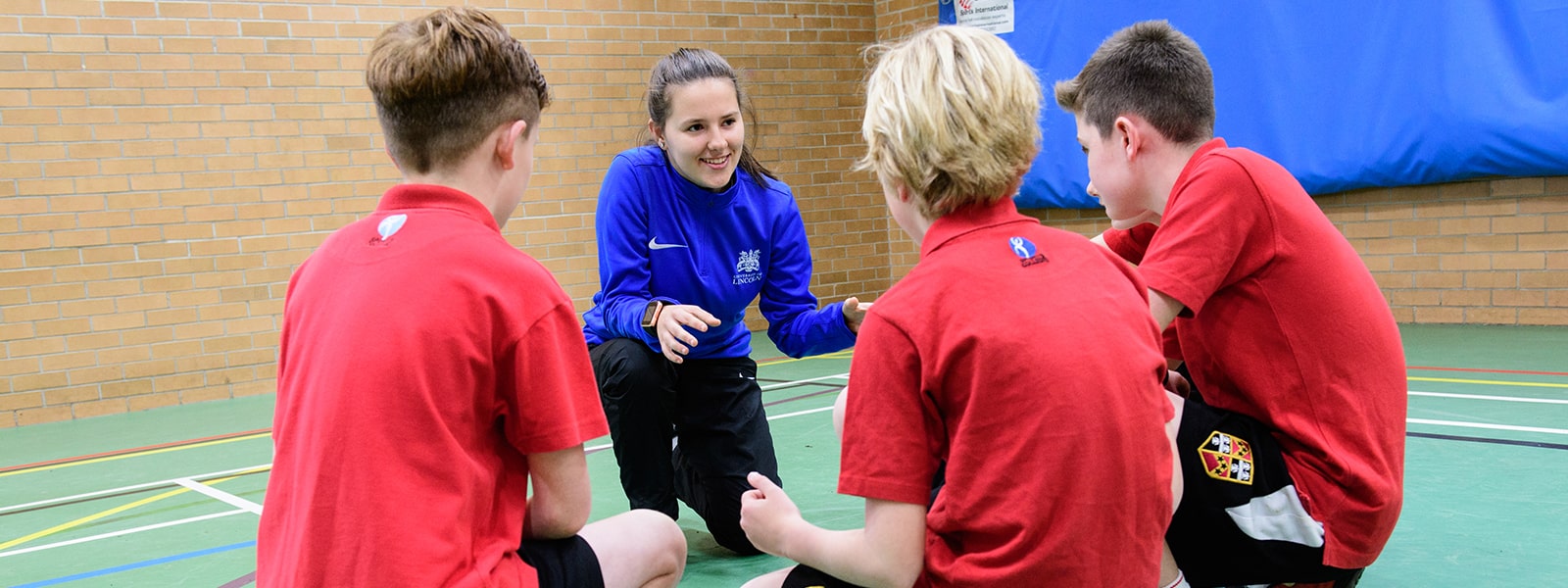 A teacher with pupils in a sports centre