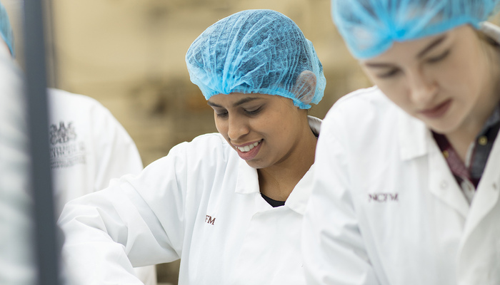 An NCFM student working in a food factory