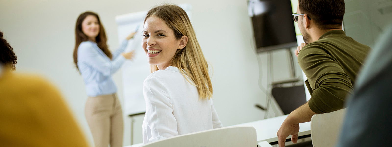 Professional woman sat in classroom looking back and smiling