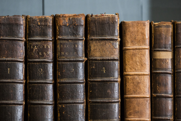A selection of old leather-bound books on a bookshelf
