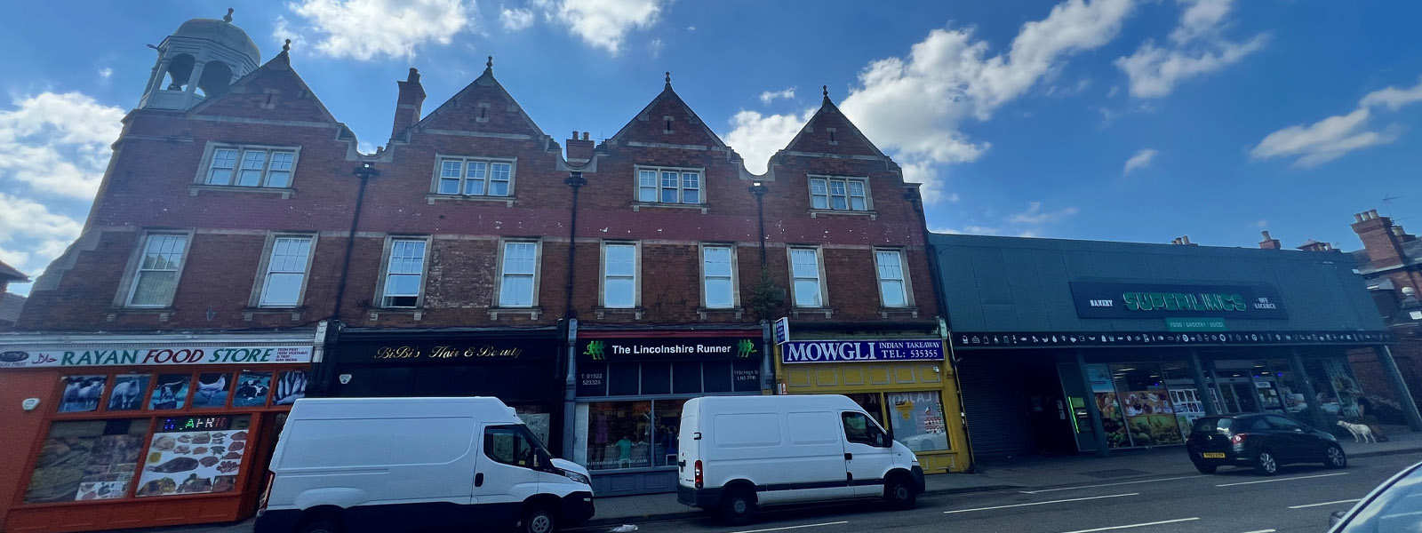 A street with shops and vehicles
