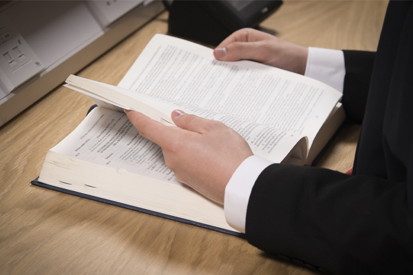 Somebody reading a book at a desk