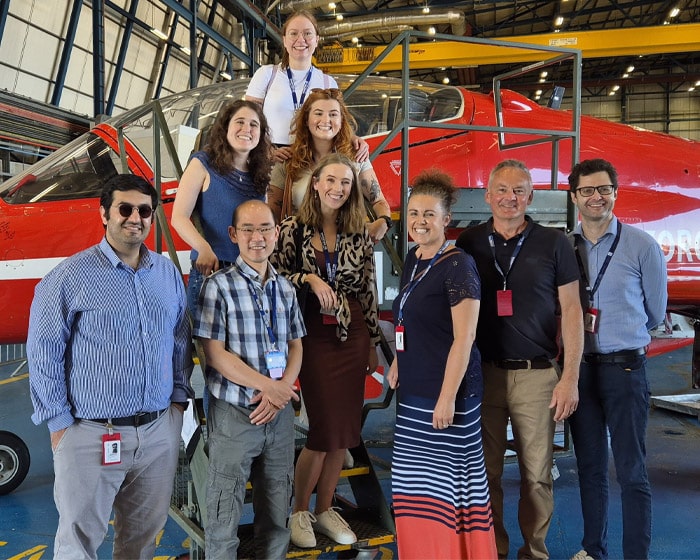 A group of people standing in front of an RAF jet
