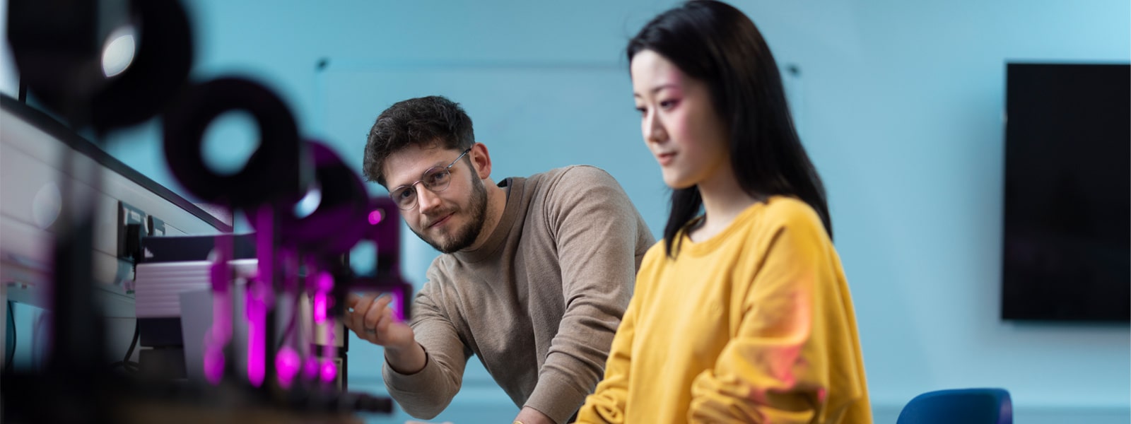 Two students working with scientific equipment in a alab