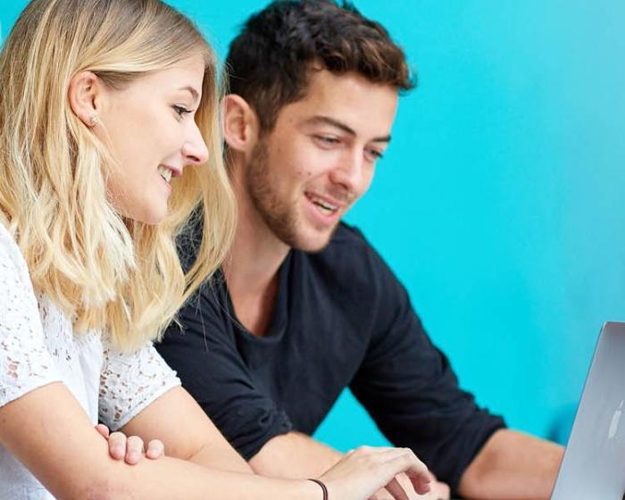 Two students looking at a laptop
